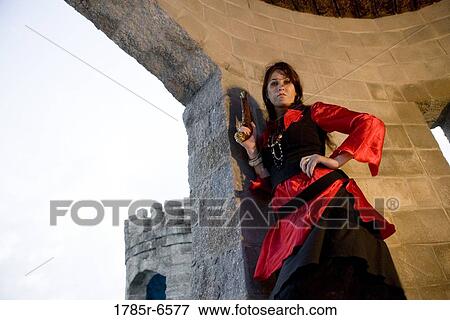 Portrait of a woman pirate armed with a pistol standing inside a castle turret View Large Photo Image Stock Photo - Portrait of a woman pirate armed with a pistol standing inside a castle turret. Fotosearch