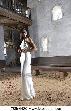 Portrait of a young bride in a white gown standing inside a medieval castle View Large Photo Image Stock Image - Portrait of a young bride in a white gown standing inside a medieval castle. Fotosearch