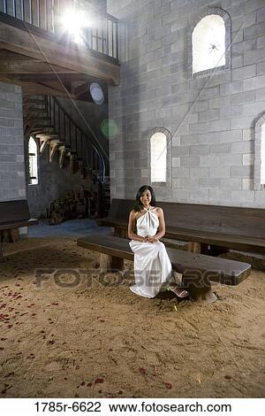 Portrait of a young bride in a white gown sitting on a bench inside a medieval castle View Large Photo Image Stock Image - Portrait of a young bride in a white gown sitting on a bench inside a medieval castle. Fotosearch