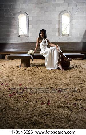 Portrait of a young bride in a white gown sitting on a bench inside a medieval castle View Large Photo Image Stock Photograph - Portrait of a young bride in a white gown sitting on a bench inside a medieval castle. Fotosearch
