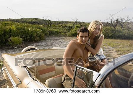 Portrait of a young couple sitting in antique convertible car View Large Photo Image Stock Image - Portrait of a young couple sitting in antique convertible car. Fotosearch