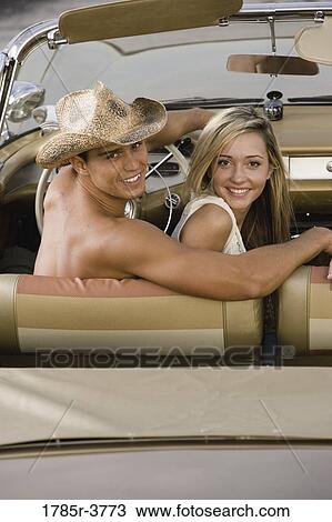 Portrait of a young couple sitting in antique convertible car View Large Photo Image Stock Image - Portrait of a young couple sitting in antique convertible car. Fotosearch