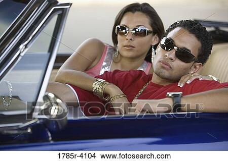 Portrait of a young hip-hop couple sitting in a convertible View Large Photo Image Picture - Portrait of a young hip-hop couple sitting in a convertible. Fotosearch