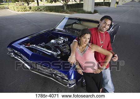 Portrait of a young hip-hop couple standing beside a pimped-up vintage car View Large Photo Image Stock Image - Portrait of a young hip-hop couple standing beside a pimped-up vintage car. Fotosearch