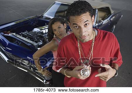 Portrait of a young hip-hop couple standing beside a pimped-up vintage car View Large Photo Image Stock Image - Portrait of a young hip-hop couple standing beside a pimped-up vintage car. Fotosearch