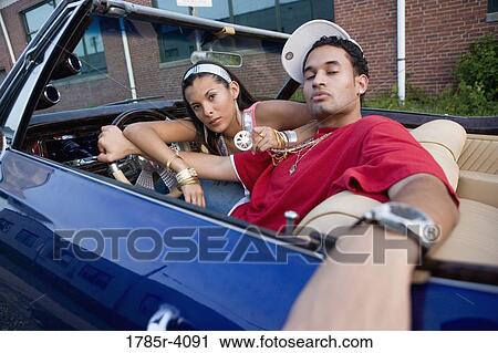 Portrait of a young hip-hop couple sitting in a pimped-up vintage car View Large Photo Image Stock Image - Portrait of a young hip-hop couple sitting in a pimped-up vintage car. Fotosearch