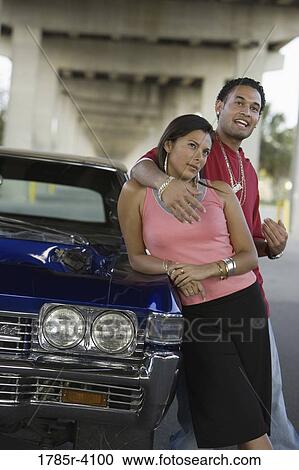 Portrait of a young hip-hop couple standing beside a pimped-up vintage car under a highway overpass View Large Photo Image Stock Image - Portrait of a young hip-hop couple standing beside a pimped-up vintage car under a highway overpass. Fotosearch
