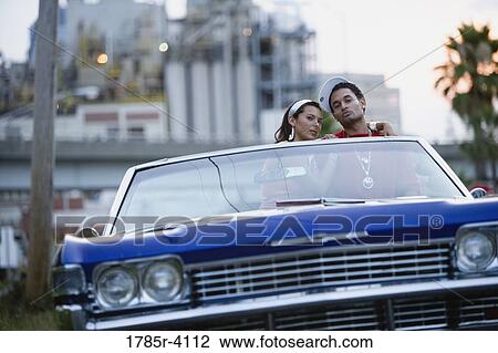 Portrait of a young hip-hop couple sitting in a pimped-up vintage car in urban neighborhood View Large Photo Image Stock Image - Portrait of a young hip-hop couple sitting in a pimped-up vintage car in urban neighborhood. Fotosearch