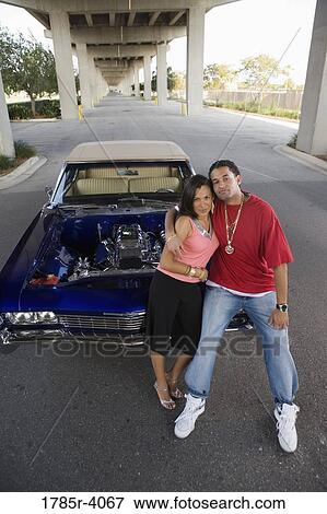 Portrait of a young hip-hop couple standing beside a pimped-up vintage car View Large Photo Image Stock Photo - Portrait of a young hip-hop couple standing beside a pimped-up vintage car. Fotosearch