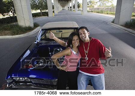 Portrait of a young hip-hop couple standing beside a pimped-up vintage car View Large Photo Image Stock Photo - Portrait of a young hip-hop couple standing beside a pimped-up vintage car. Fotosearch