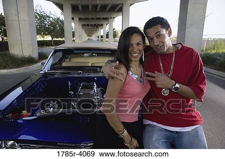 Portrait of a young hip-hop couple standing beside a pimped-up vintage car View Large Photo Image Stock Photo - Portrait of a young hip-hop couple standing beside a pimped-up vintage car. Fotosearch