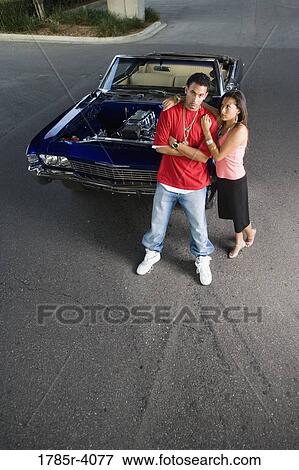 Portrait of a young hip-hop couple standing beside a pimped-up vintage car View Large Photo Image Stock Photo - Portrait of a young hip-hop couple standing beside a pimped-up vintage car. Fotosearch