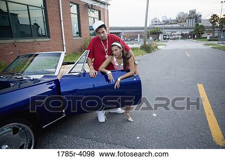 Portrait of a young hip-hop couple sitting in a pimped-up vintage car in depressed urban neighborhood View Large Photo Image Stock Photo - Portrait of a young hip-hop couple sitting in a pimped-up vintage car in depressed urban neighborhood. Fotosearch
