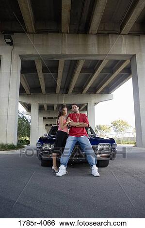 Portrait of a young hip-hop couple standing beside a pimped-up vintage car View Large Photo Image Stock Photograph - Portrait of a young hip-hop couple standing beside a pimped-up vintage car. Fotosearch