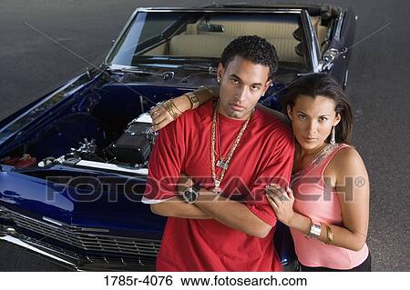 Portrait of a young hip-hop couple standing beside a pimped-up vintage car View Large Photo Image Stock Photograph - Portrait of a young hip-hop couple standing beside a pimped-up vintage car. Fotosearch
