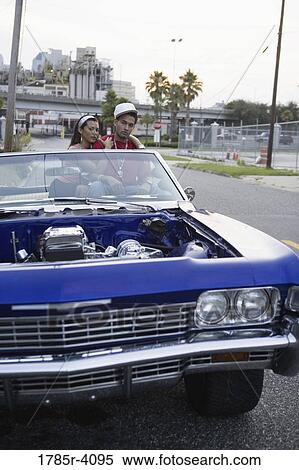 Portrait of a young hip-hop couple sitting in a pimped-up vintage car in urban neighborhood View Large Photo Image Stock Photography - Portrait of a young hip-hop couple sitting in a pimped-up vintage car in urban neighborhood. Fotosearch