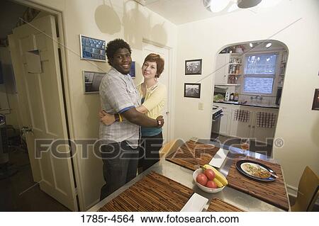 Picture - Portrait of a young inter-racial couple hugging. Fotosearch