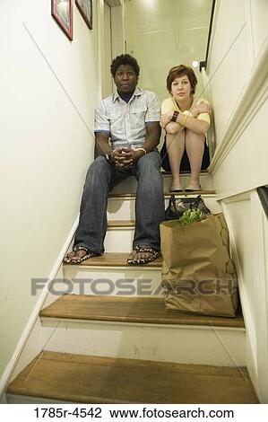 Portrait of a young inter-racial couple sitting on top of a stairway View Large Photo Image Stock Image - Portrait of a young inter-racial couple sitting on top of a stairway. Fotosearch