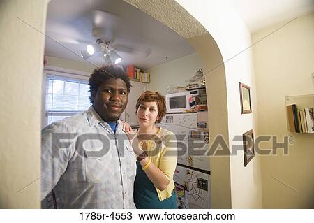 Portrait of a young inter-racial couple smiling outside kitchen View Large Photo Image Stock Image - Portrait of a young inter-racial couple smiling outside kitchen. Fotosearch