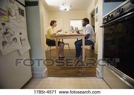 Portrait of a young inter-racial couple sitting at dining table View Large Photo Image Stock Image - Portrait of a young inter-racial couple sitting at dining table. Fotosearch