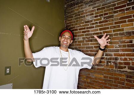 Portrait of a young man in hip-hop fashion standing showing gangsta hand gestures View Large Photo Image Stock Image - Portrait of a young man in hip-hop fashion standing showing gangsta hand gestures. Fotosearch