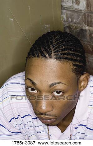 Portrait of a young man in hip-hop fashion sitting against brick wall View Large Photo Image Stock Photo - Portrait of a young man in hip-hop fashion sitting against brick wall. Fotosearch