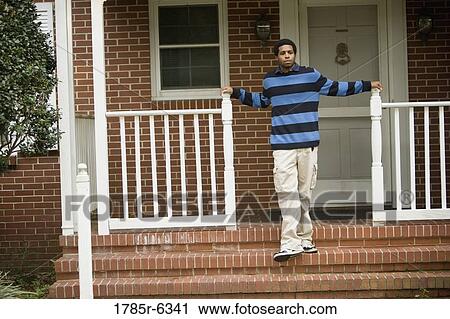 Portrait of a young man standing on front porch of house View Large Photo Image Stock Image - Portrait of a young man standing on front porch of house. Fotosearch