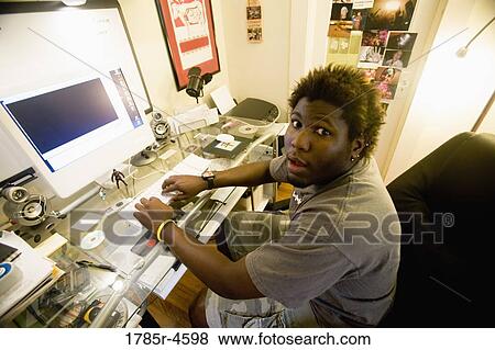 Stock Photo - Portrait of a young man using computer. Fotosearch