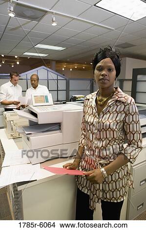 Portrait of a young woman next to copier in the office View Large Photo Image Picture - Portrait of a young woman next to copier in the office. Fotosearch