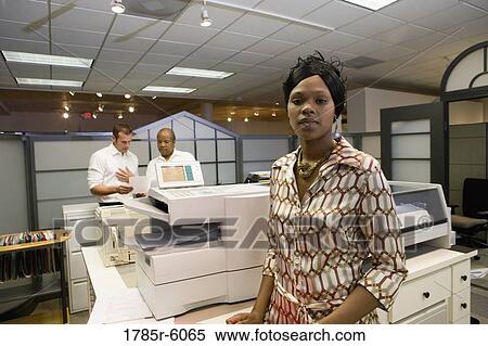 Portrait of a young woman next to copier in the office View Large Photo Image Stock Photography - Portrait of a young woman next to copier in the office. Fotosearch