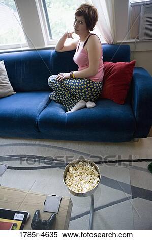 Portrait of a young woman sitting on a sofa View Large Photo Image Stock Photography - Portrait of a young woman sitting on a sofa. Fotosearch