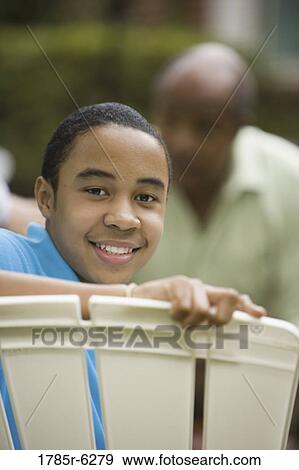 Portrait of African boy smiling with father in background View Large Photo Image Stock Photo - Portrait of African boy smiling with father in background. Fotosearch