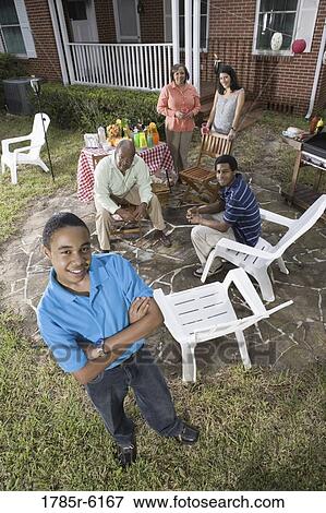 Portrait of African teenage boy with family and friends in background View Large Photo Image Stock Photo - Portrait of African teenage boy with family and friends in background. Fotosearch