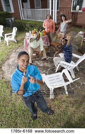 Portrait of African teenage boy with family and friends in background View Large Photo Image Stock Photo - Portrait of African teenage boy with family and friends in background. Fotosearch