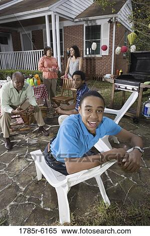 Portrait of African teenage boy with family and friends in background View Large Photo Image Stock Photography - Portrait of African teenage boy with family and friends in background. Fotosearch
