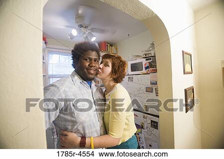 Portrait of an affectionate young inter-racial couple outside kitchen View Large Photo Image Picture - Portrait of an affectionate young inter-racial couple outside kitchen. Fotosearch