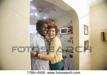Portrait of an affectionate young inter-racial couple outside kitchen View Large Photo Image Stock Photography - Portrait of an affectionate young inter-racial couple outside kitchen. Fotosearch