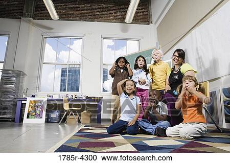 Portrait of an art teacher posing with her students making funny faces View Large Photo Image Stock Image - Portrait of an art teacher posing with her students making funny faces. Fotosearch