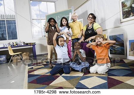 Portrait of an art teacher posing with her students making funny faces View Large Photo Image Stock Photo - Portrait of an art teacher posing with her students making funny faces. Fotosearch