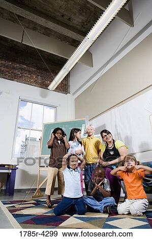 Stock Photo - Portrait of an art teacher posing with her students making funny faces. Fotosearch