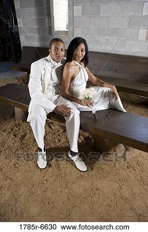 Portrait of bride and groom in white sitting on a bench inside a medieval castle View Large Photo Image Stock Image - Portrait of bride and groom in white sitting on a bench inside a medieval castle. Fotosearch