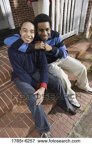 Portrait of brothers sitting on front steps of house View Large Photo Image Stock Photo - Portrait of brothers sitting on front steps of house. Fotosearch