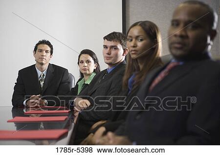 Portrait of business executives sitting abreast in a formal conference room View Large Photo Image Stock Photo - Portrait of business executives sitting abreast in a formal conference room. Fotosearch