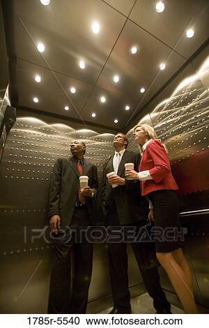 Portrait of business people riding in an elevator View Large Photo Image Stock Image - Portrait of business people riding in an elevator. Fotosearch