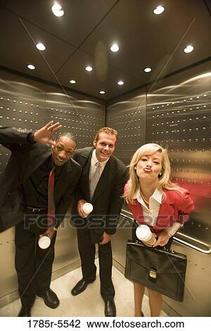 Stock Image - Portrait of business people riding in an elevator. Fotosearch