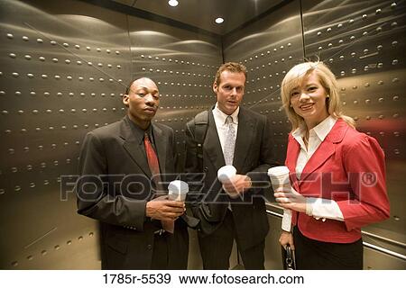 Portrait of business people riding in an elevator View Large Photo Image Stock Photo - Portrait of business people riding in an elevator. Fotosearch