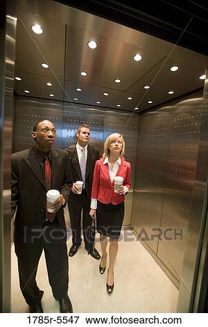 Portrait of business people riding in an elevator View Large Photo Image Stock Photo - Portrait of business people riding in an elevator. Fotosearch