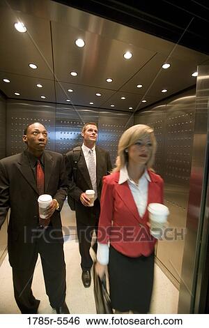 Portrait of business people riding in an elevator View Large Photo Image Stock Photograph - Portrait of business people riding in an elevator. Fotosearch