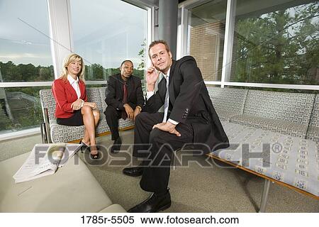 Stock Photography - Portrait of business people sitting in an office lobby. Fotosearch