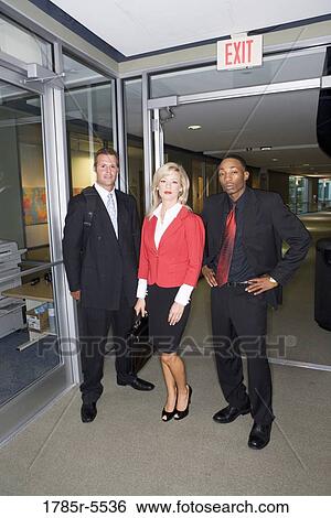 Portrait of business people standing and waiting in an office hallway View Large Photo Image Stock Photograph - Portrait of business people standing and waiting in an office hallway. Fotosearch
